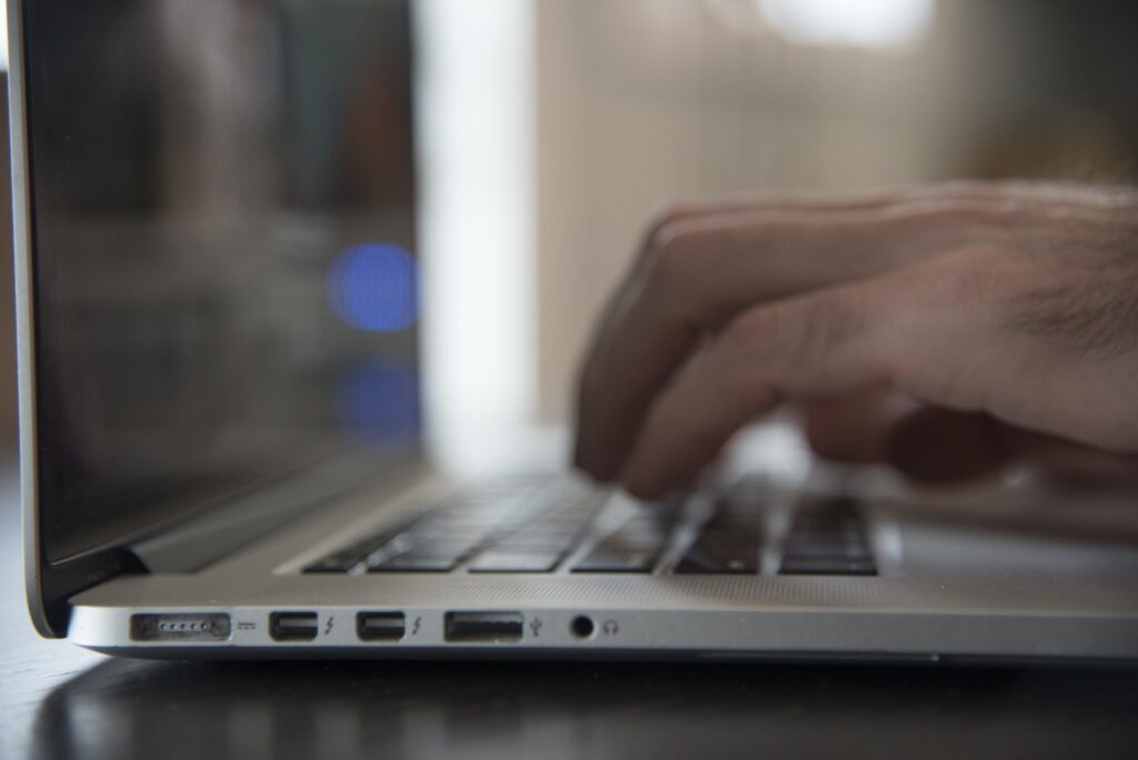 Laptop Connectivity, side ports on a laptop computer with hands typing