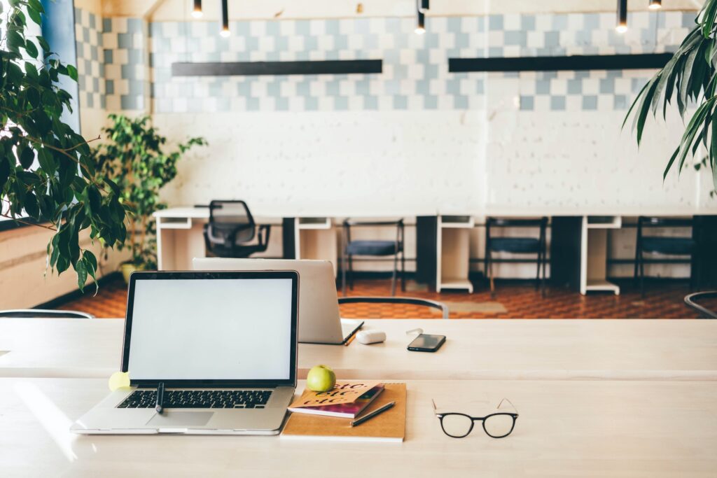 Laptops on table in meeting room of office workspace.