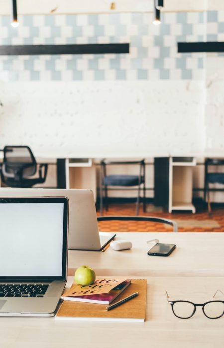 Laptops on table in meeting room of office workspace.